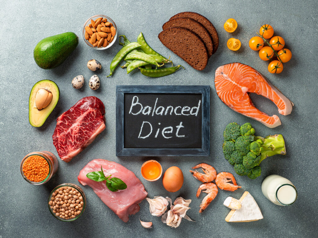 Balanced diet - healthy food on gray stone background. Various food ingredients and chalkboard with words Balanced Diet. Top view or flat lay.