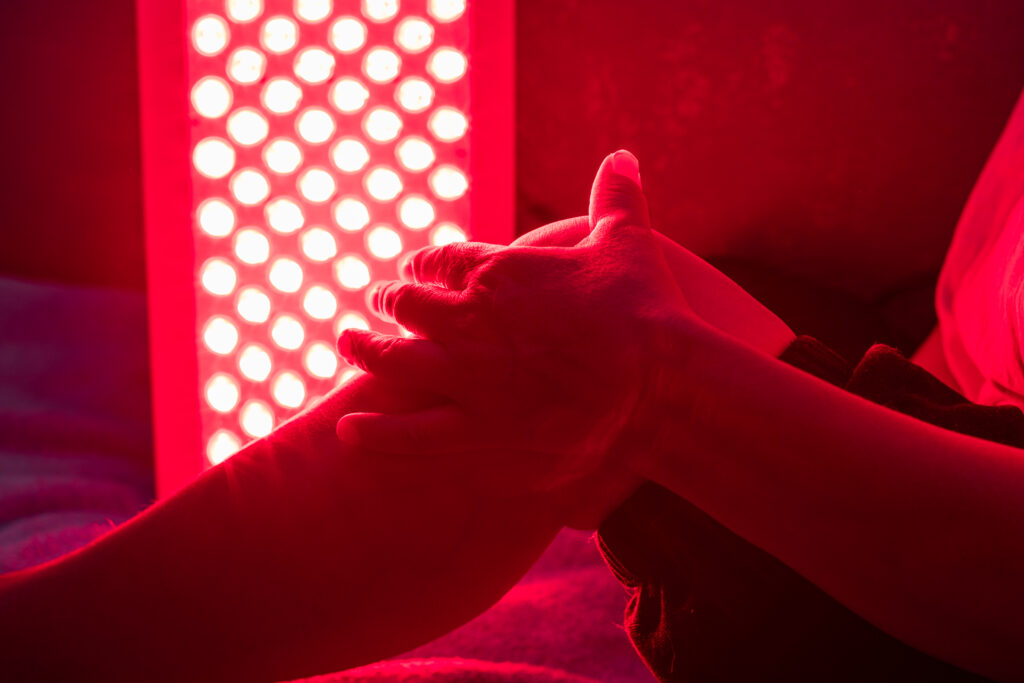 Closeup of sore leg of a person treating with the red light therapy panel