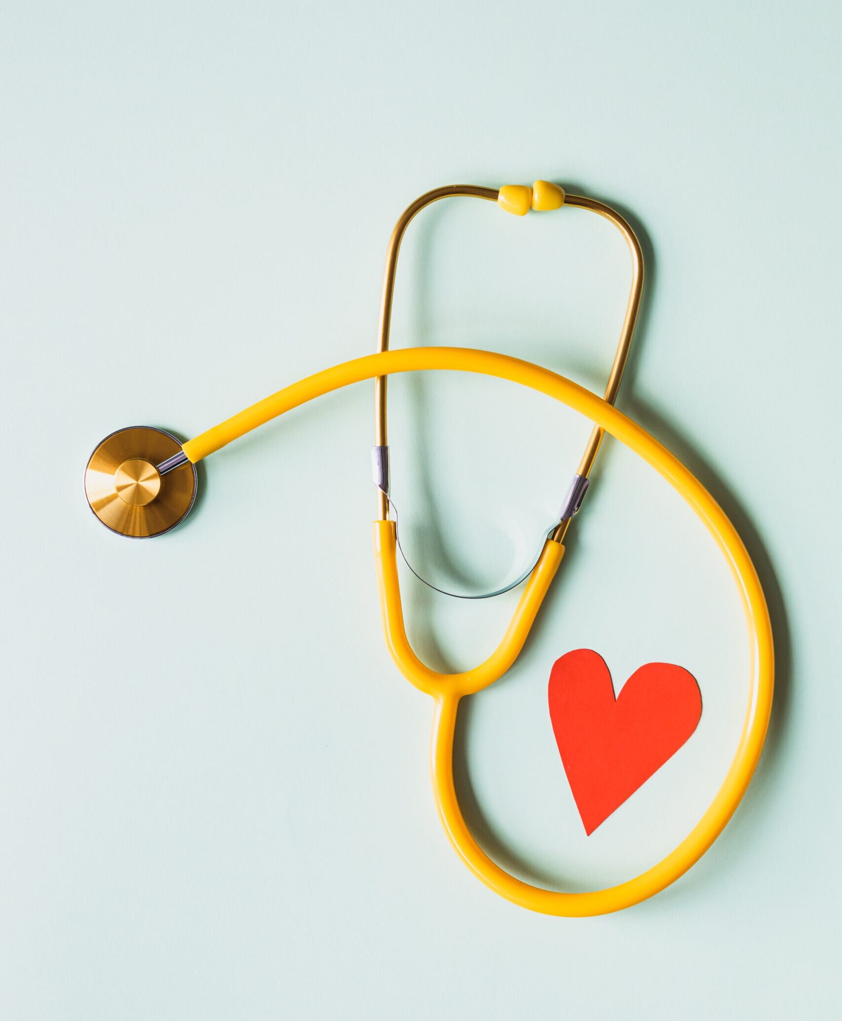 medical-stethoscope-with-red-paper-heart-on-white-surface